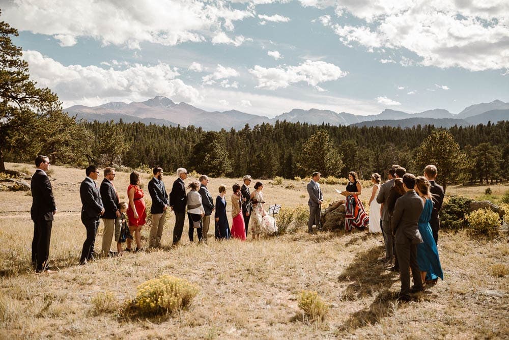 Bride and groom surrounded by their friends and family during intimate elopement ceremony in Rocky Mountain National Park, Colorado. 