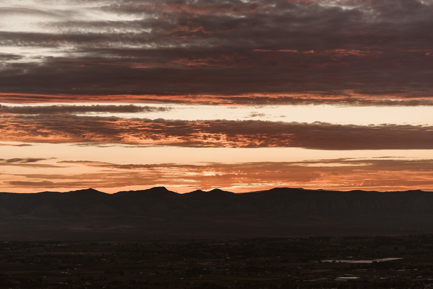 Landscape of mountain range and sunrise at Colorado National Monument.