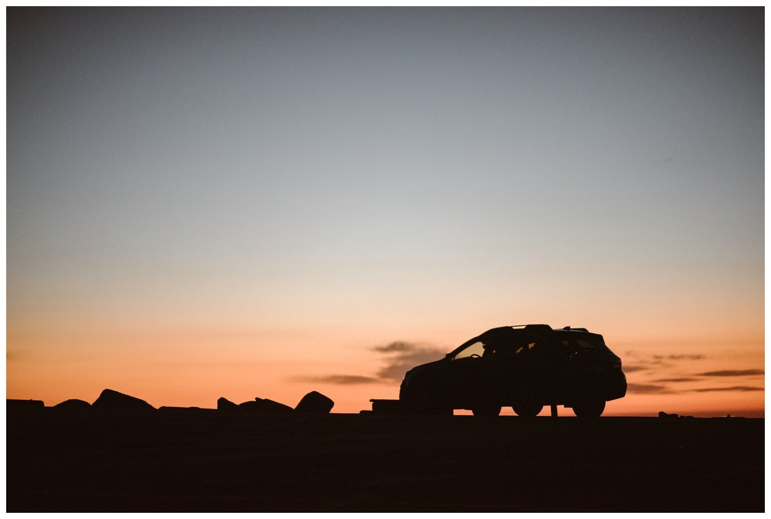 Silhouette of a car at sunrise.