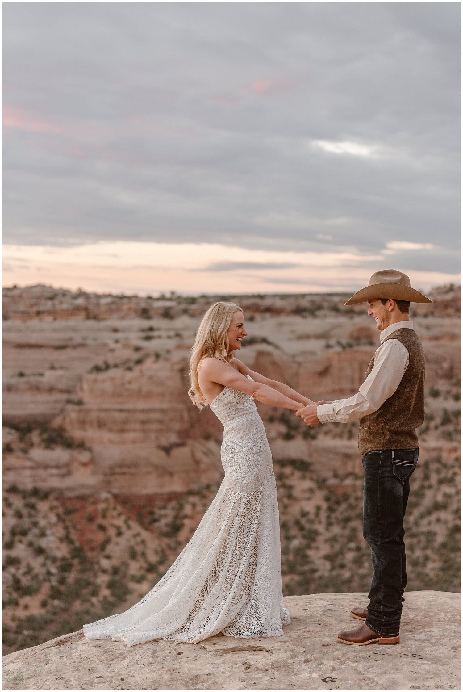 Bride and groom hold hands and smiling at each other at Colorado National Monument. 
