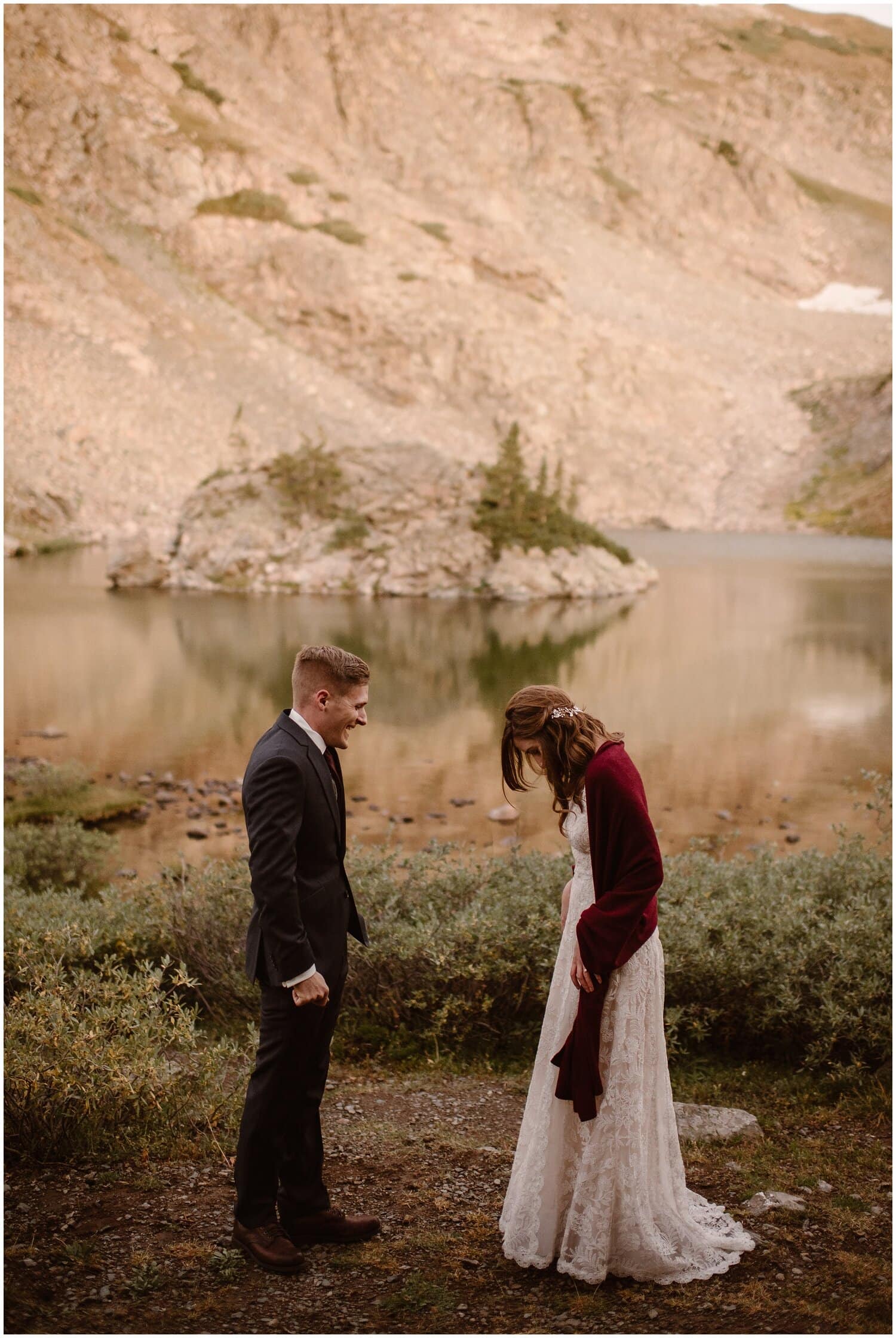 Bride and groom have first look in front of alpine lake with island in Buena Vista, Colorado. 