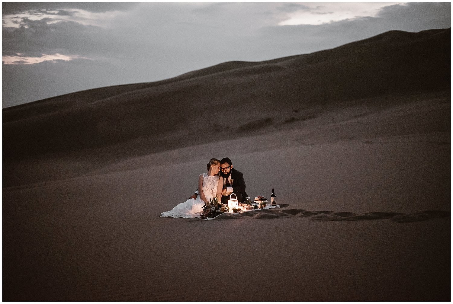 Bride and groom have picnic in the desert. 