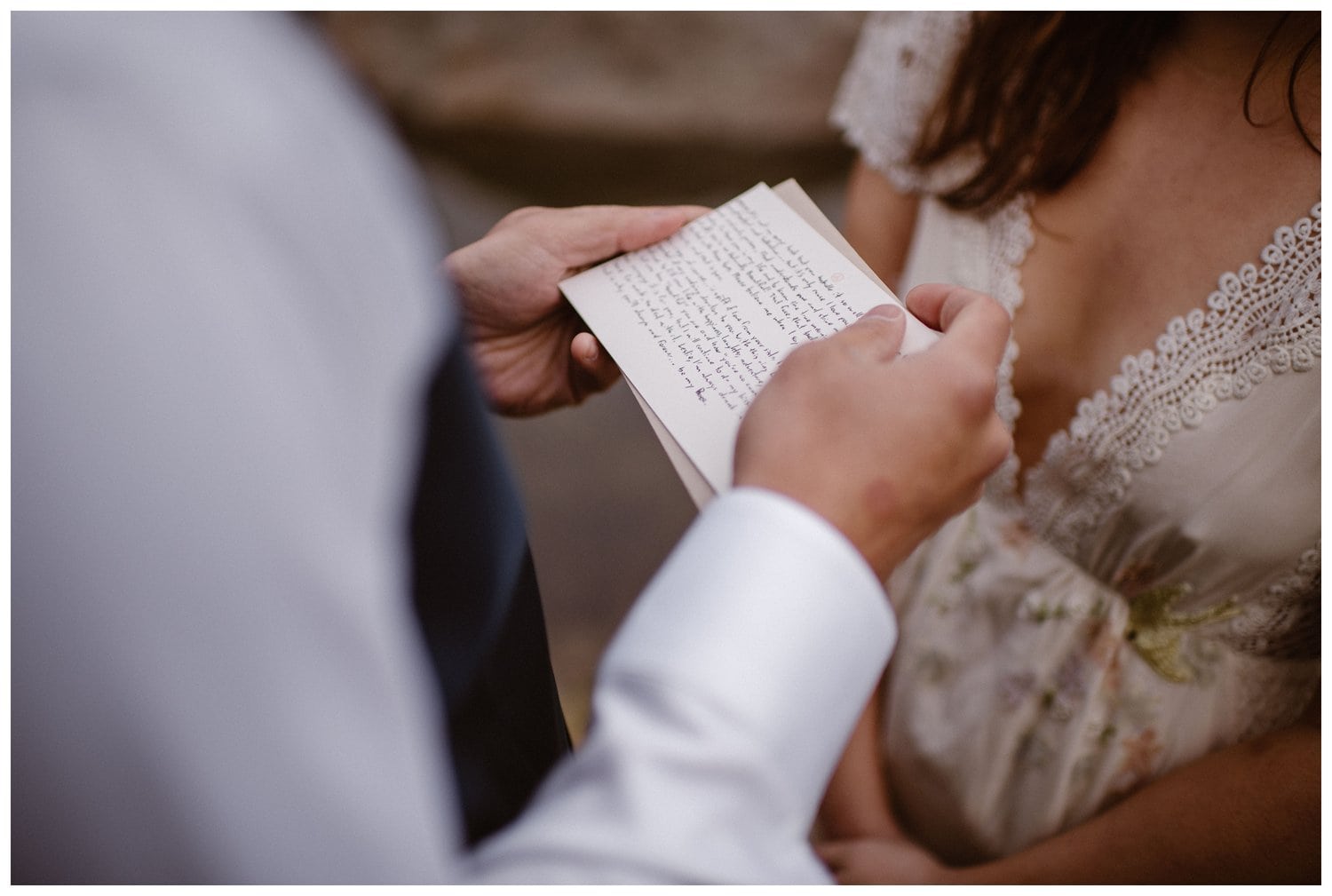 Close-up of groom holding his vows during their intimate elopement ceremony. 