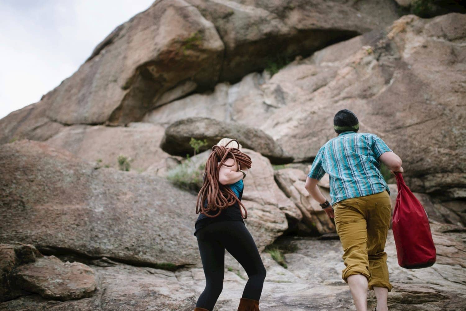 Couple hike up mountain with rock climbing gear in Buena Vista, Colorado. 