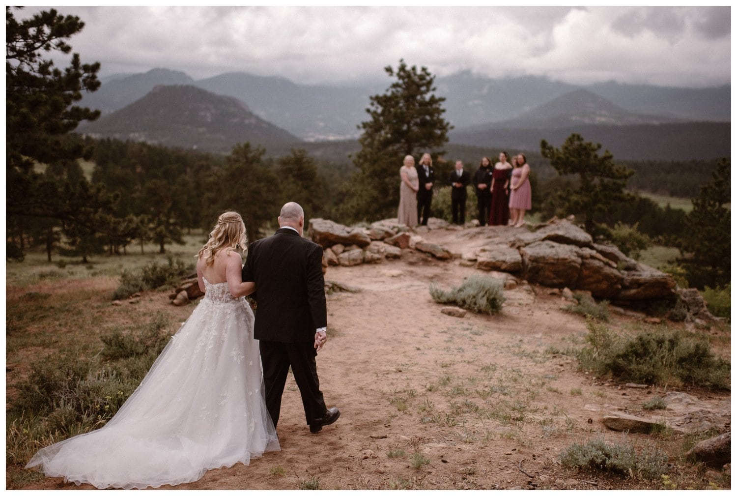 Bride walks with father towards the groom for their elopement ceremony at 3M Curve in Rocky Mountain National Park, Colorado. 