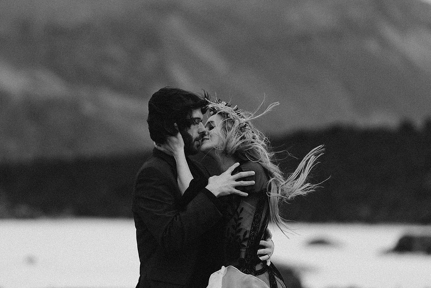 Black and white image of bride and groom kissing. 