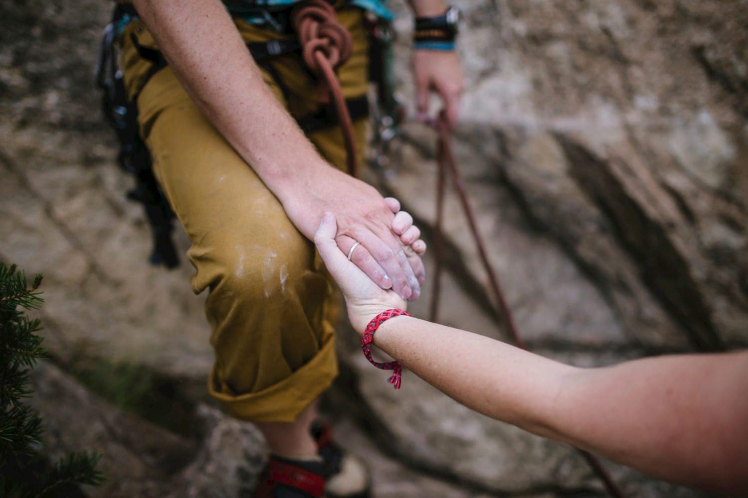 Close-up of couple holding hands while rock climbing in Buena Vista, Colorado. 