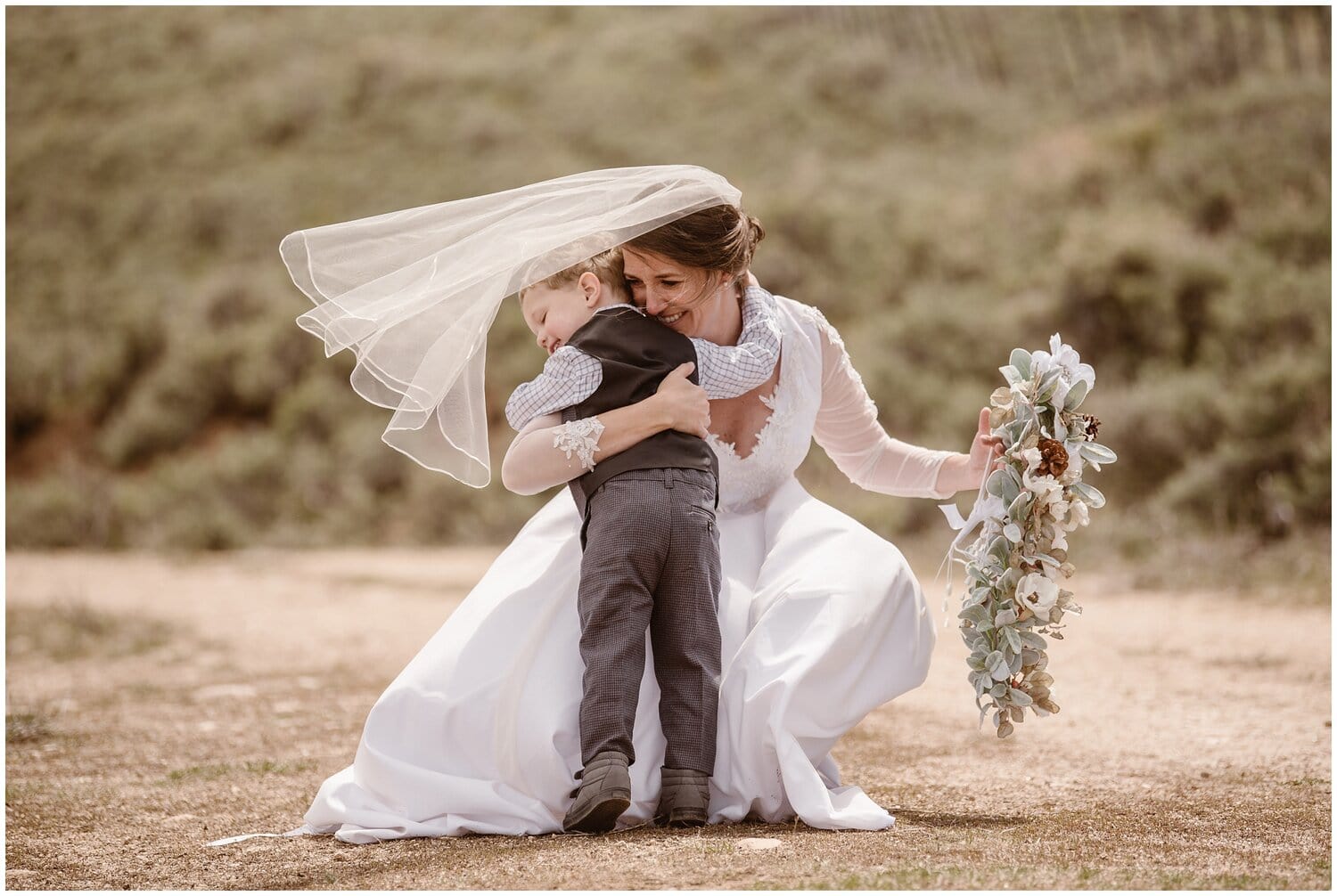 Bride leans down to hug boy, both are smiling. 