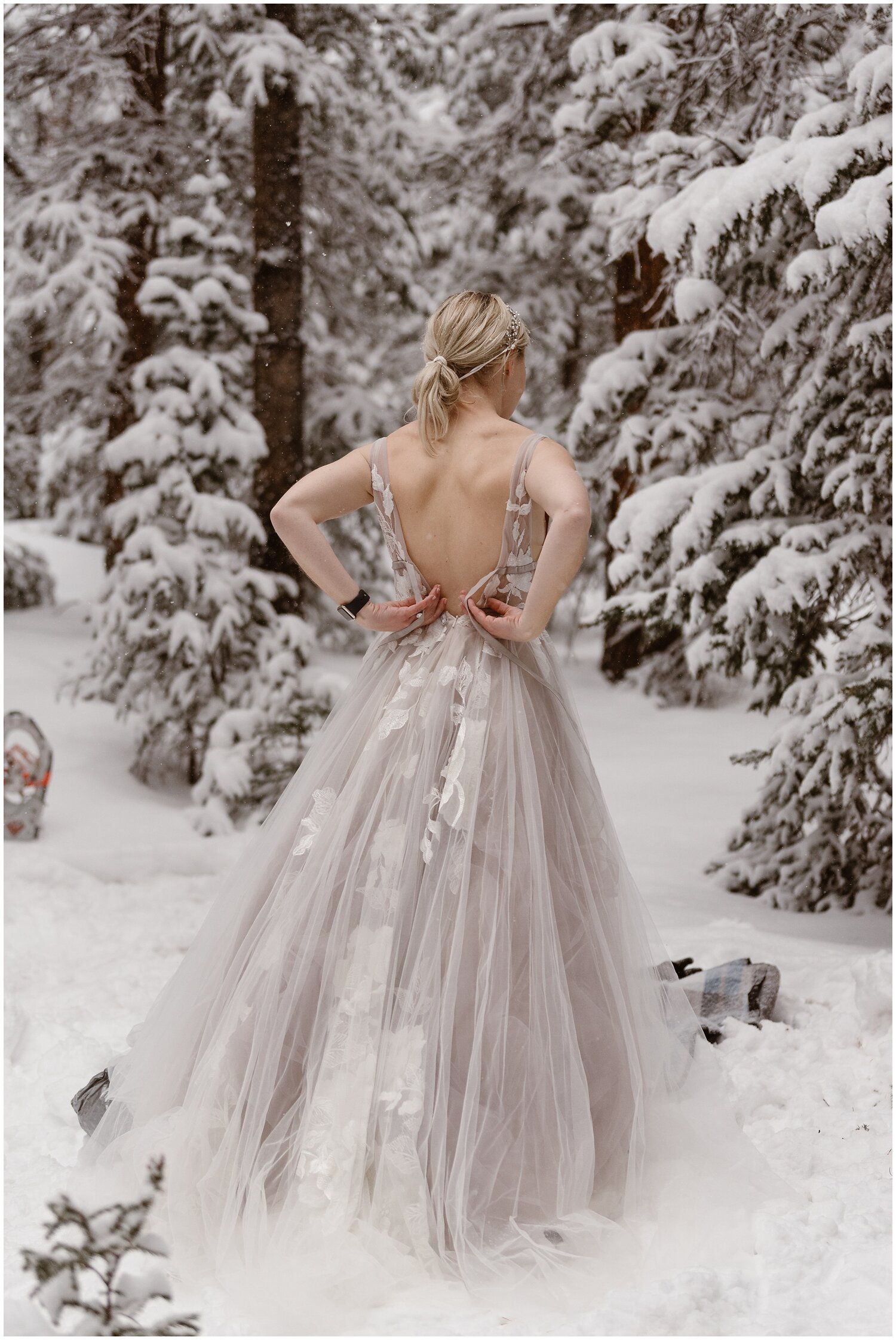Bride gets dressed in the snow. 
