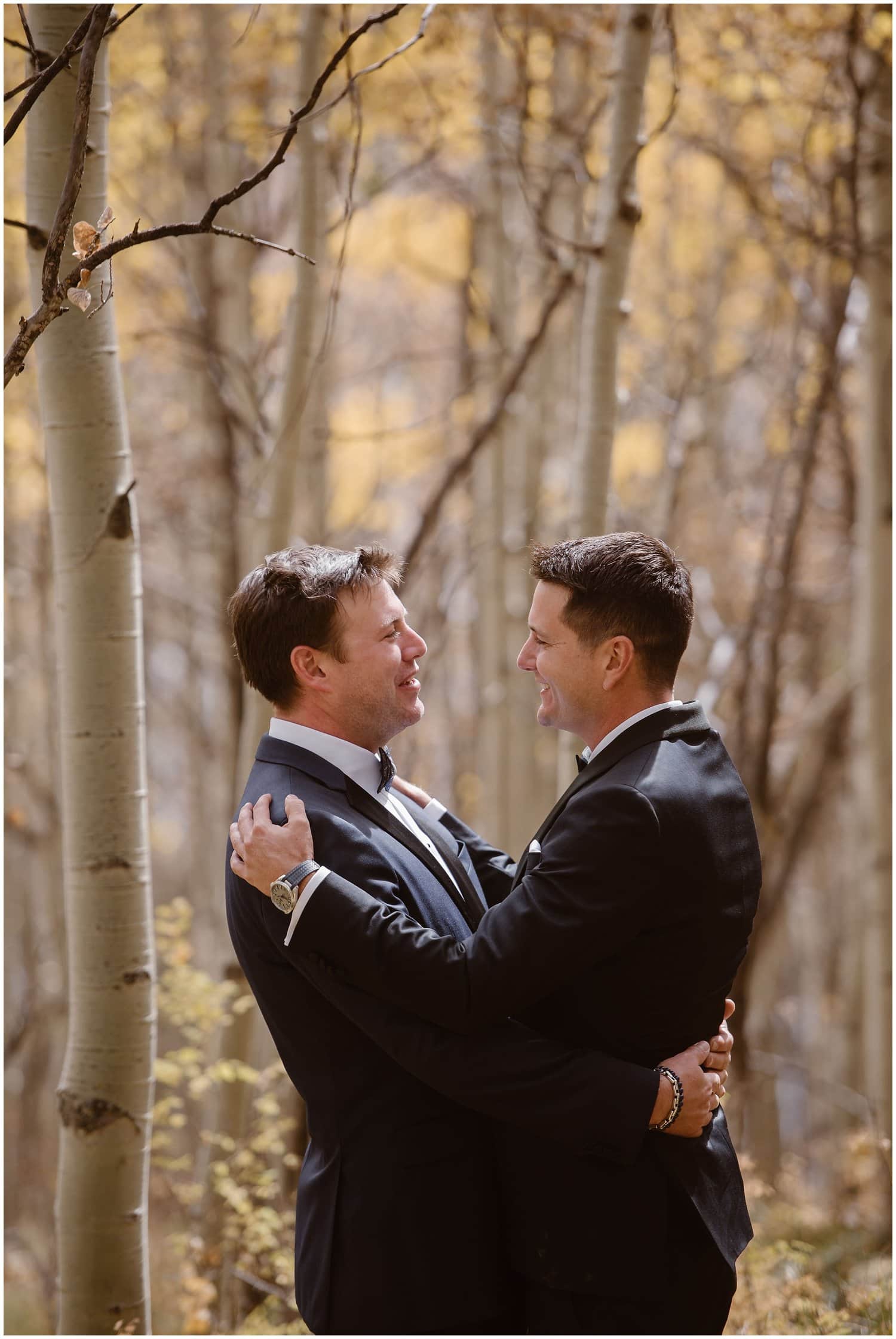 Grooms hug in aspen grove in Ouray, Colorado. 