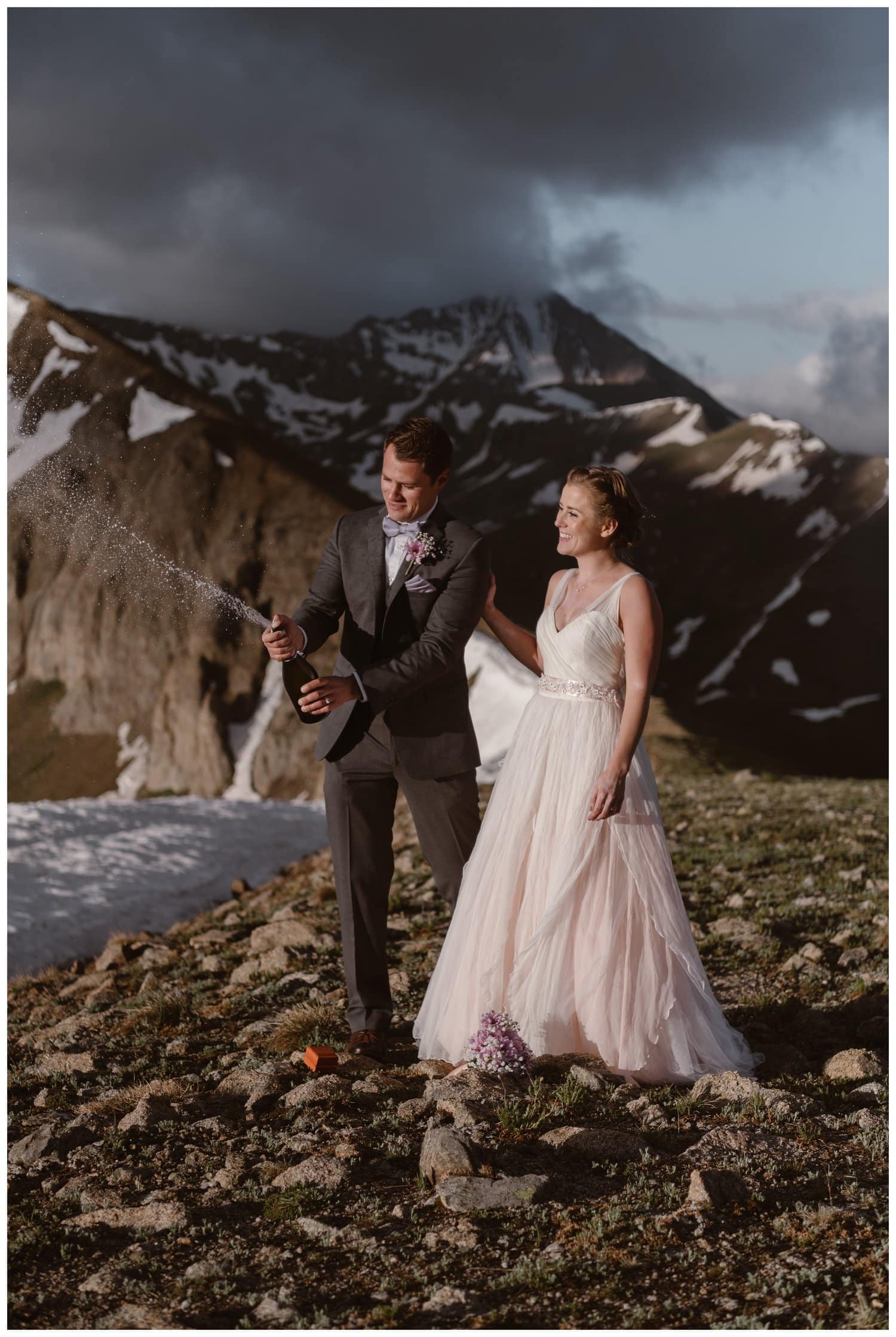 Bride and groom pop champagne  during a sunrise hiking elopement near Aspen, Colorado. 