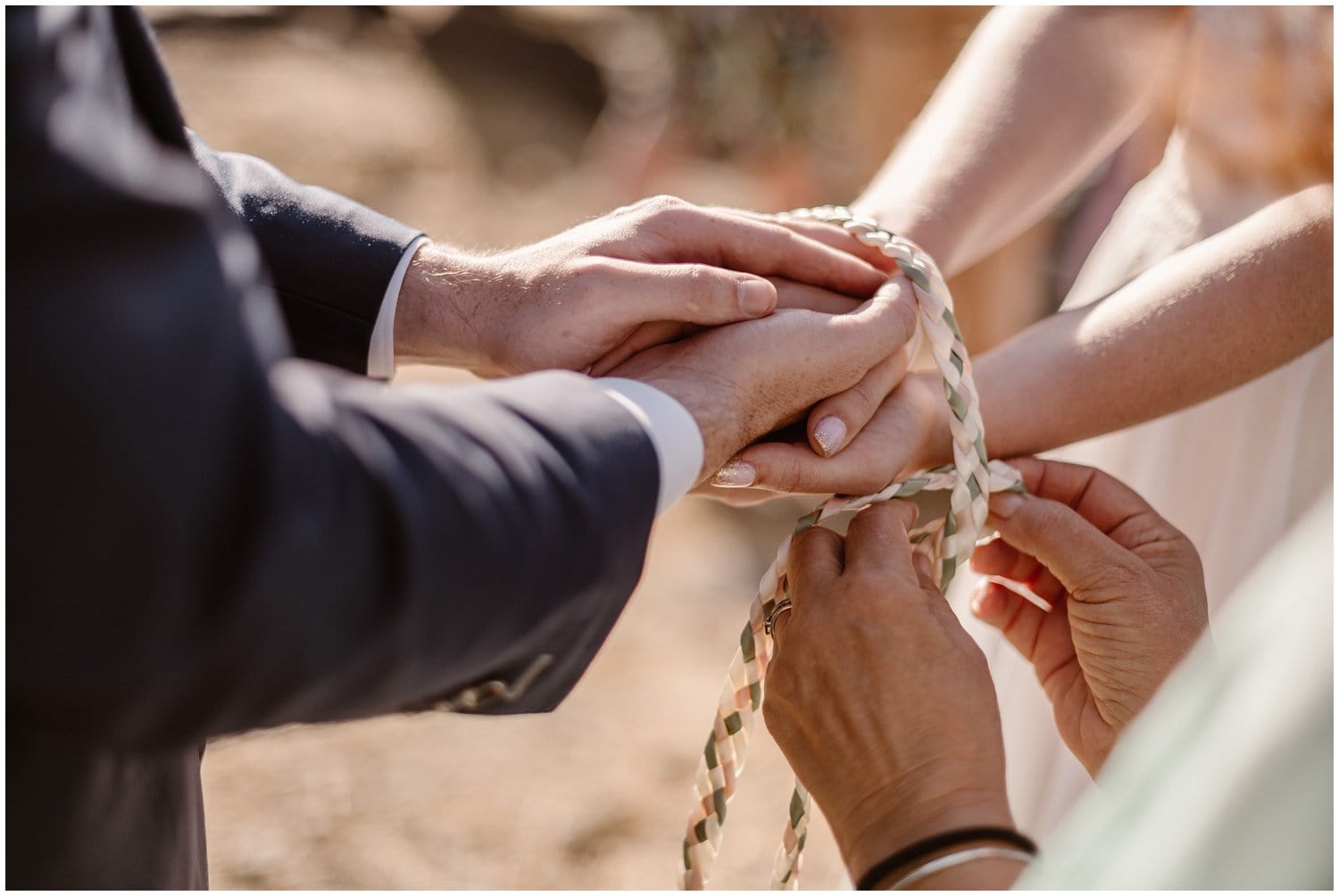 Officiant wraps braided rope around the bride and grooms hands during their intimate elopement ceremony. 