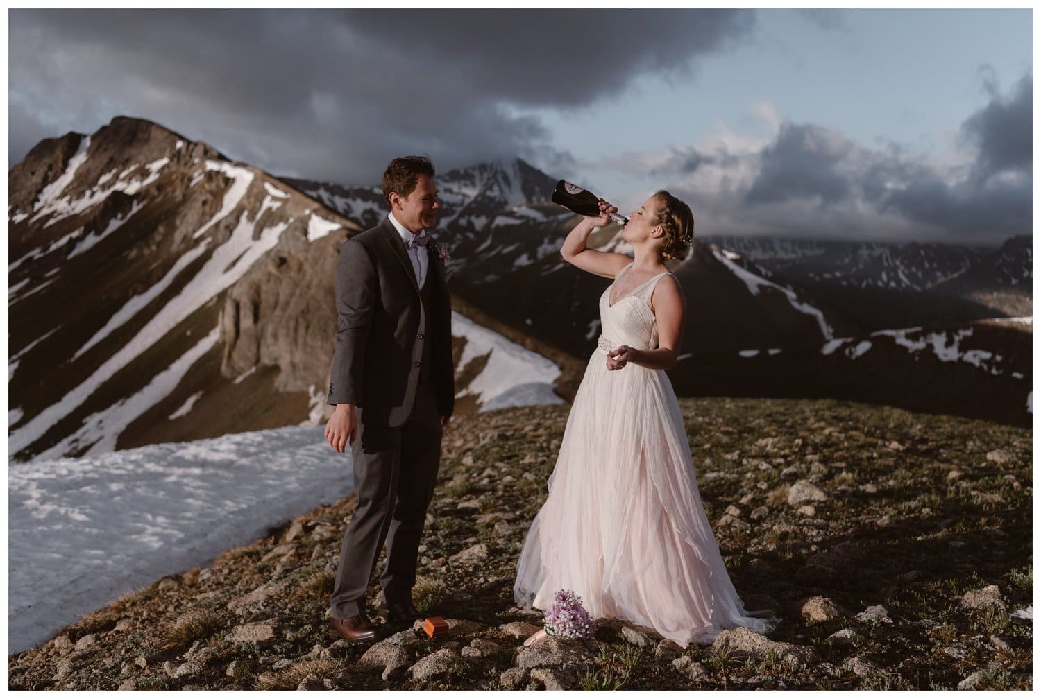 Bride and groom drink champagne during a sunrise hiking elopement near Aspen, Colorado. 
