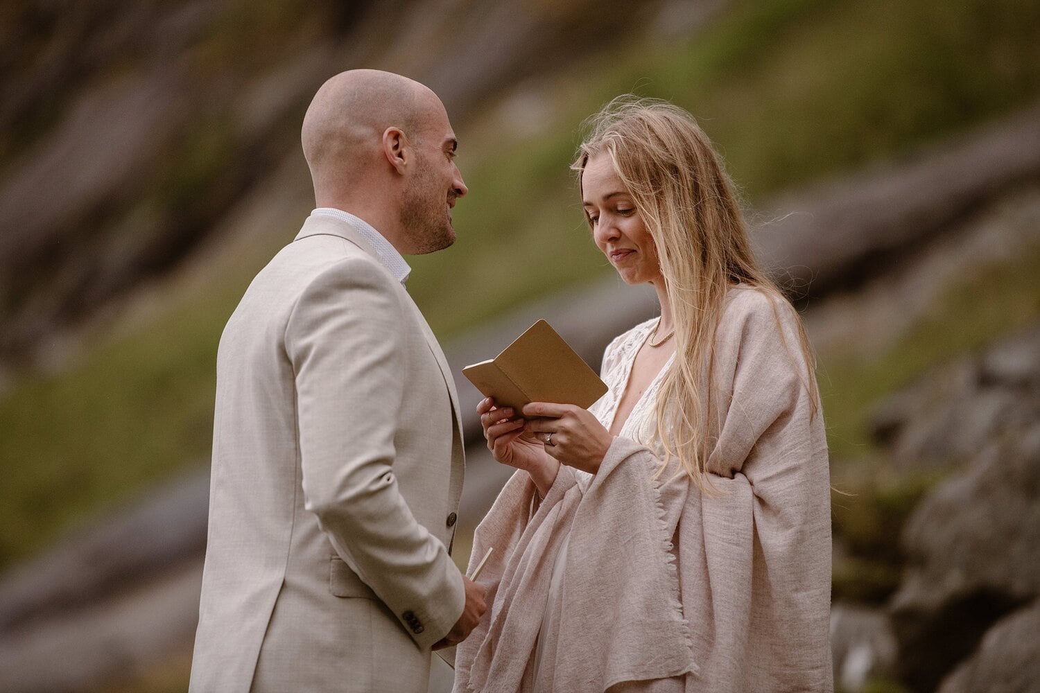 Bride reads her vows during intimate elopement ceremony on a beach in Norway.