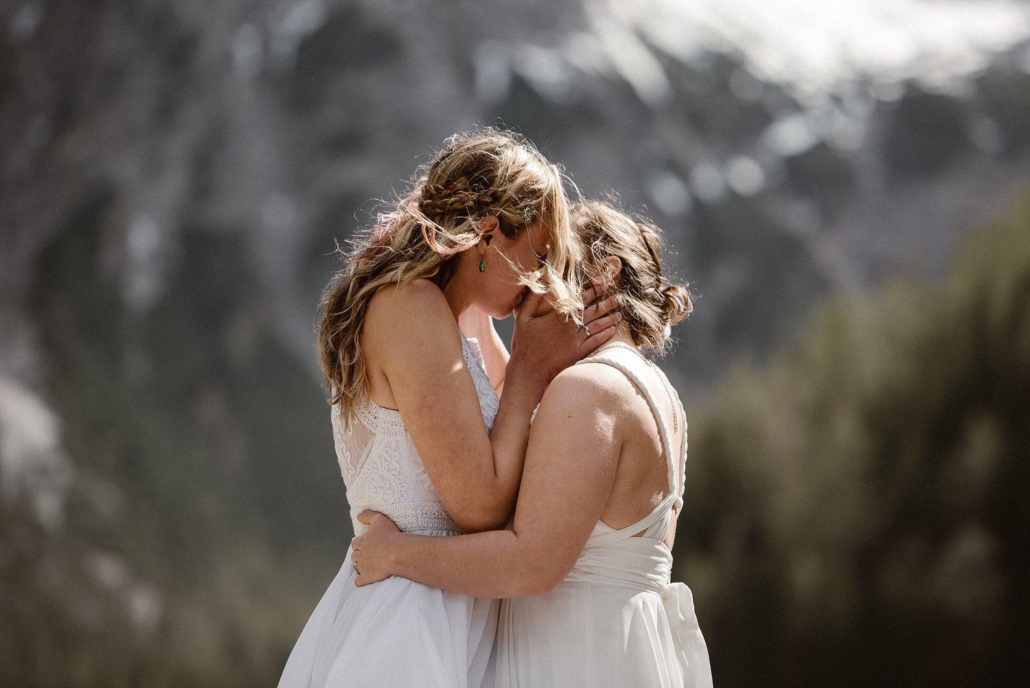 Two brides kiss during intimate elopement ceremony at Lago De Braies in Italy. 