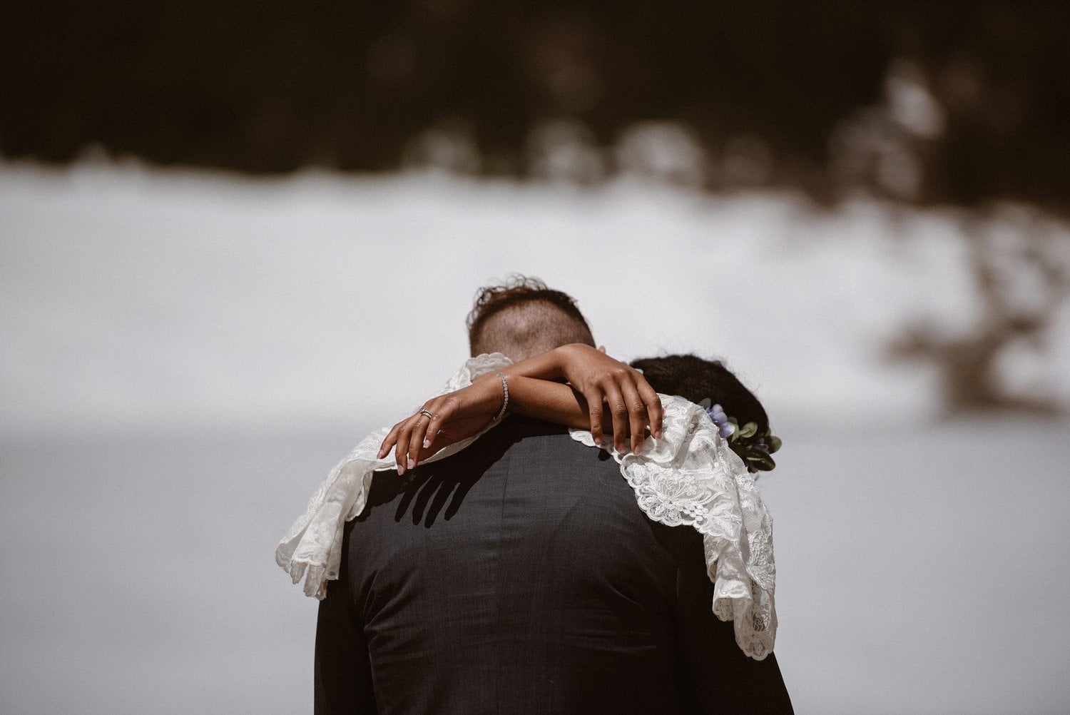 Bride and groom embrace during winter elopement at Loveland Pass, in Colorado. 