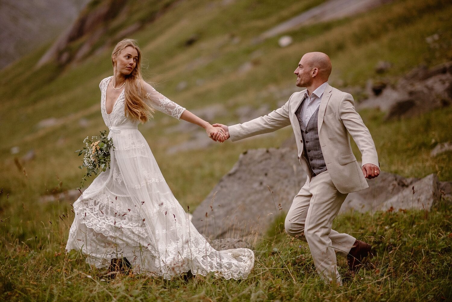 Bride and groom hold hands and look into each others eyes on their elopement day in Norway.