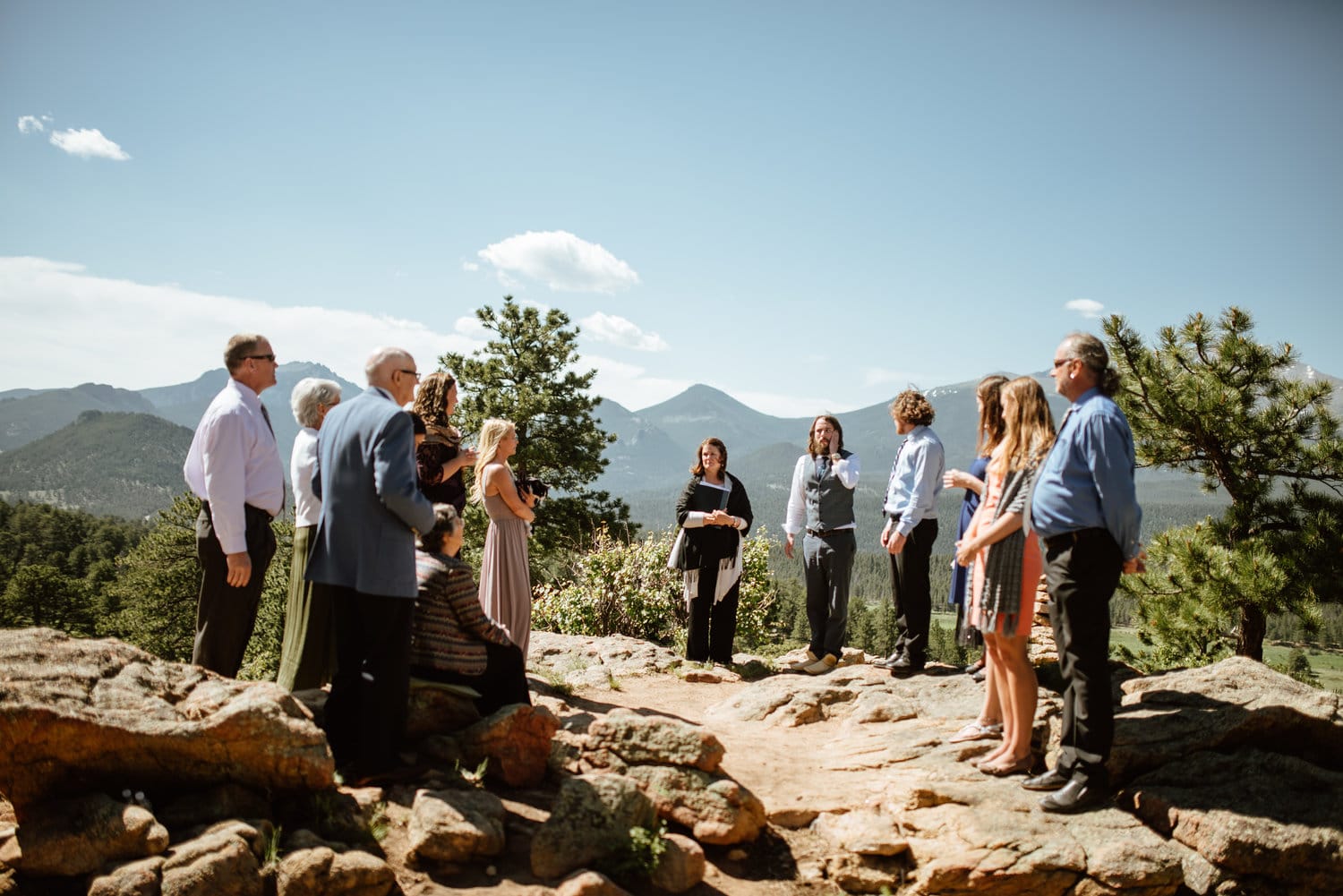 Friends and family stand around groom for ceremony at 3M Curse in Rocky Mountain National Park, Colorado. 