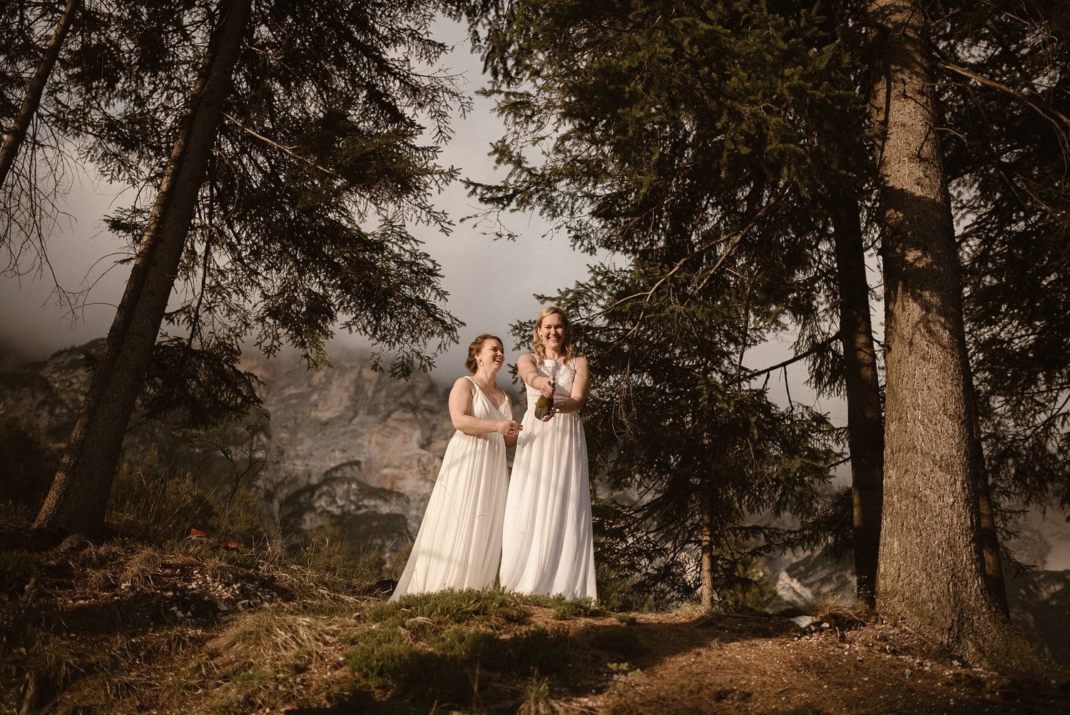 Two brides pop champagne on their elopement day in Italy. 
