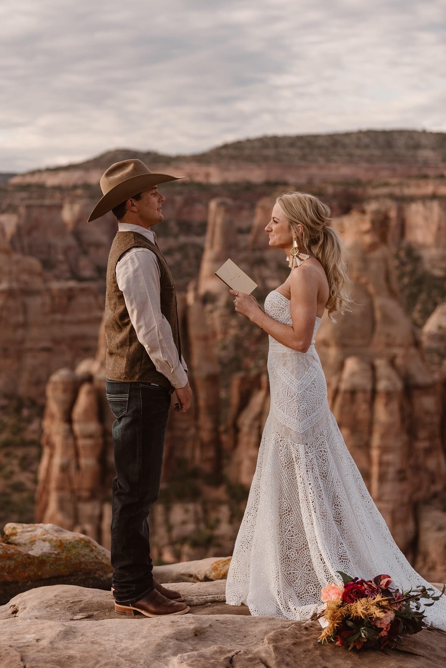 Bride and groom read their vows during desert adventure elopement at Colorado National Monument. 
