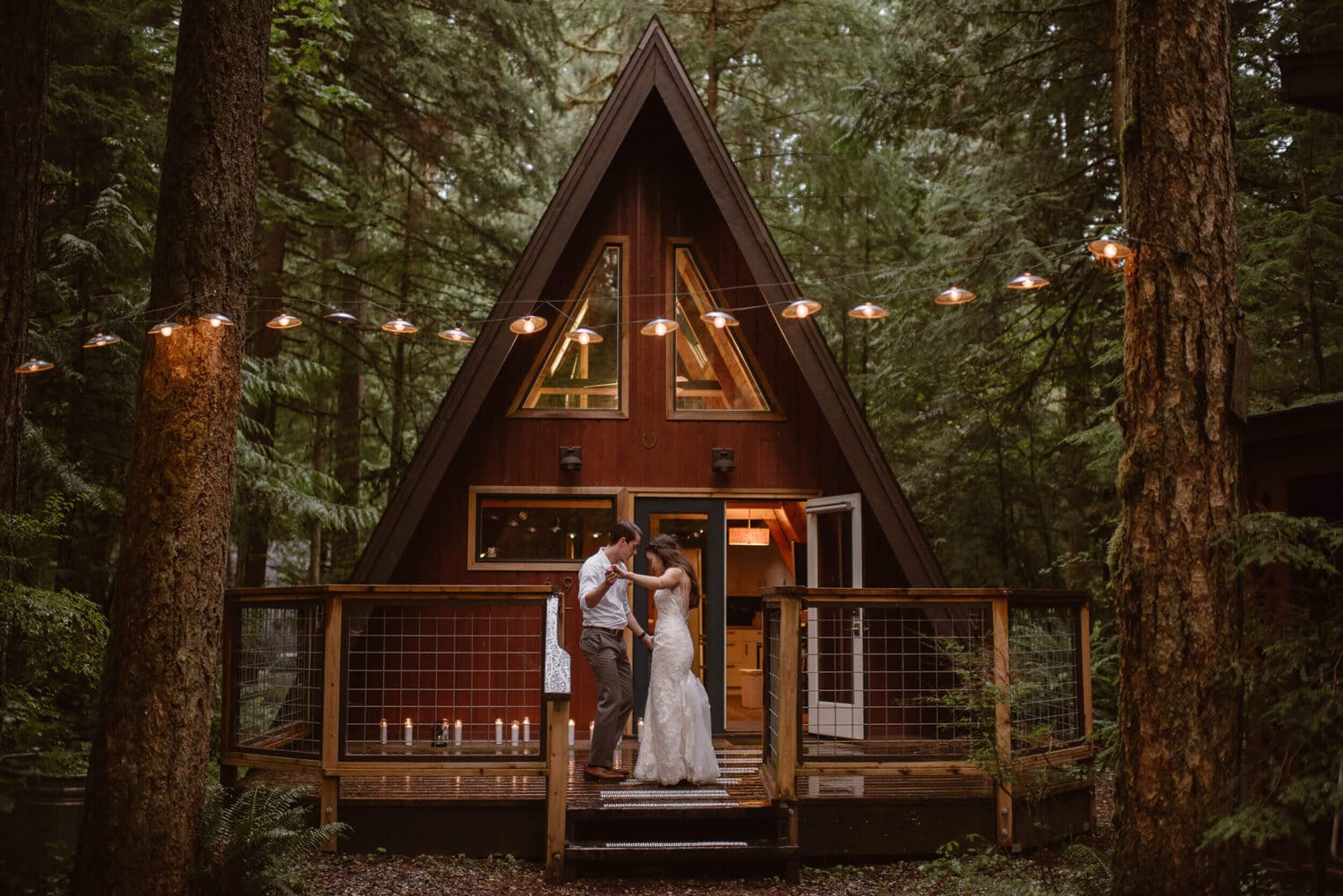 Bride and groom stand in front of an Airbnb treehouse for their wedding.