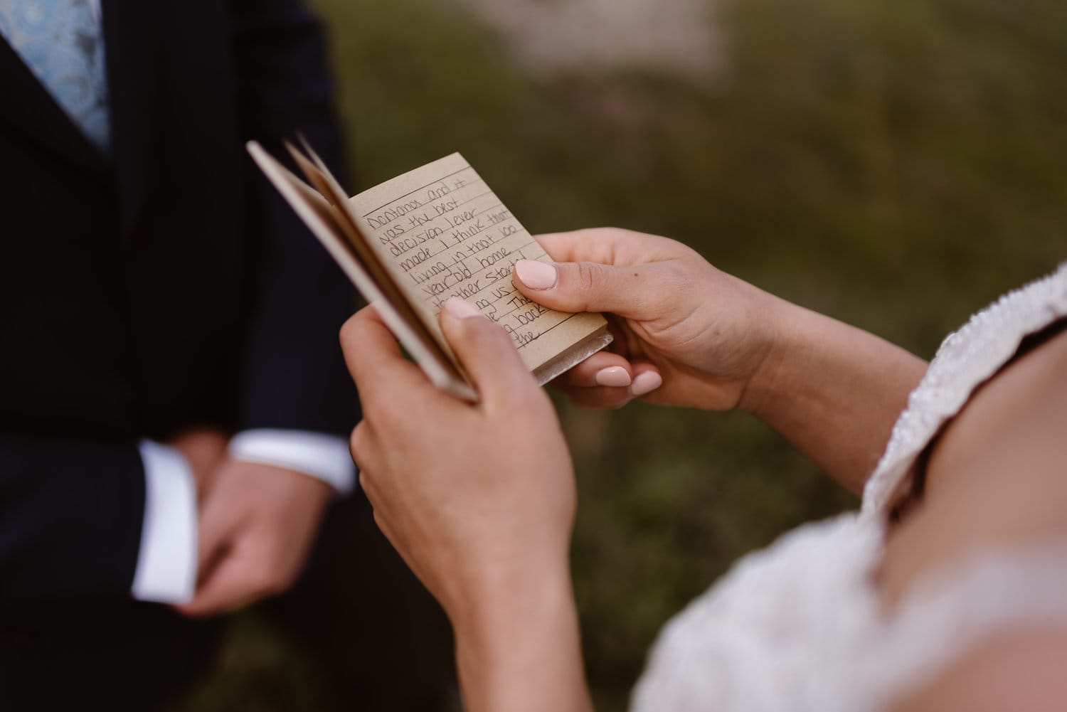 Close-up of bride holding her hand-written vows. 