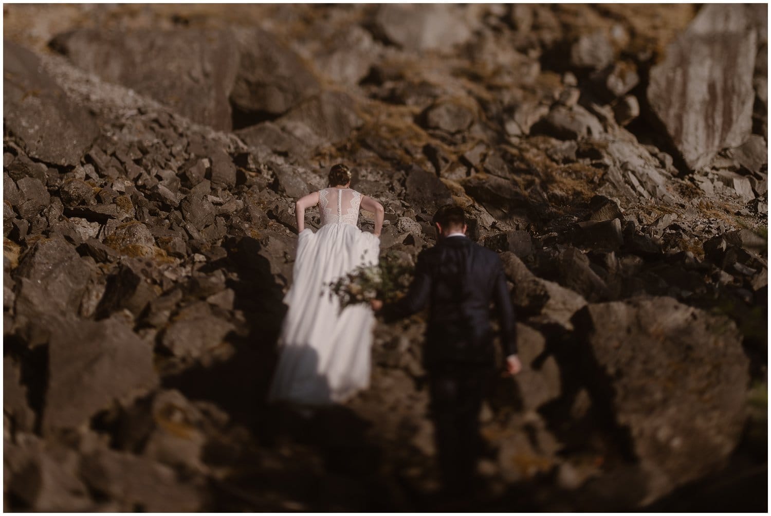 Bride and groom hike up coastal rocks at the Columbia River Gorge in Oregon.