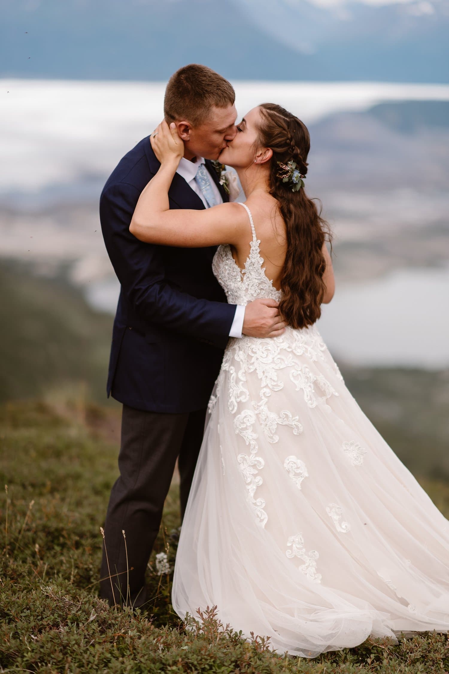 Bride and groom share a kiss during intimate elopement ceremony in Alaska. 