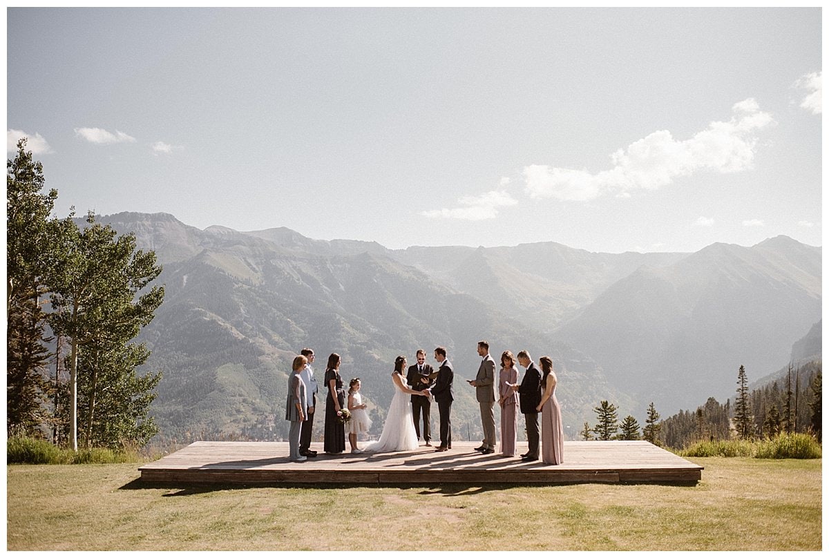 Bride and groom surrounded by their friends and family during intimate elopement ceremony at the San Sophia Overlook at Telluride Ski Resort in Colorado. 