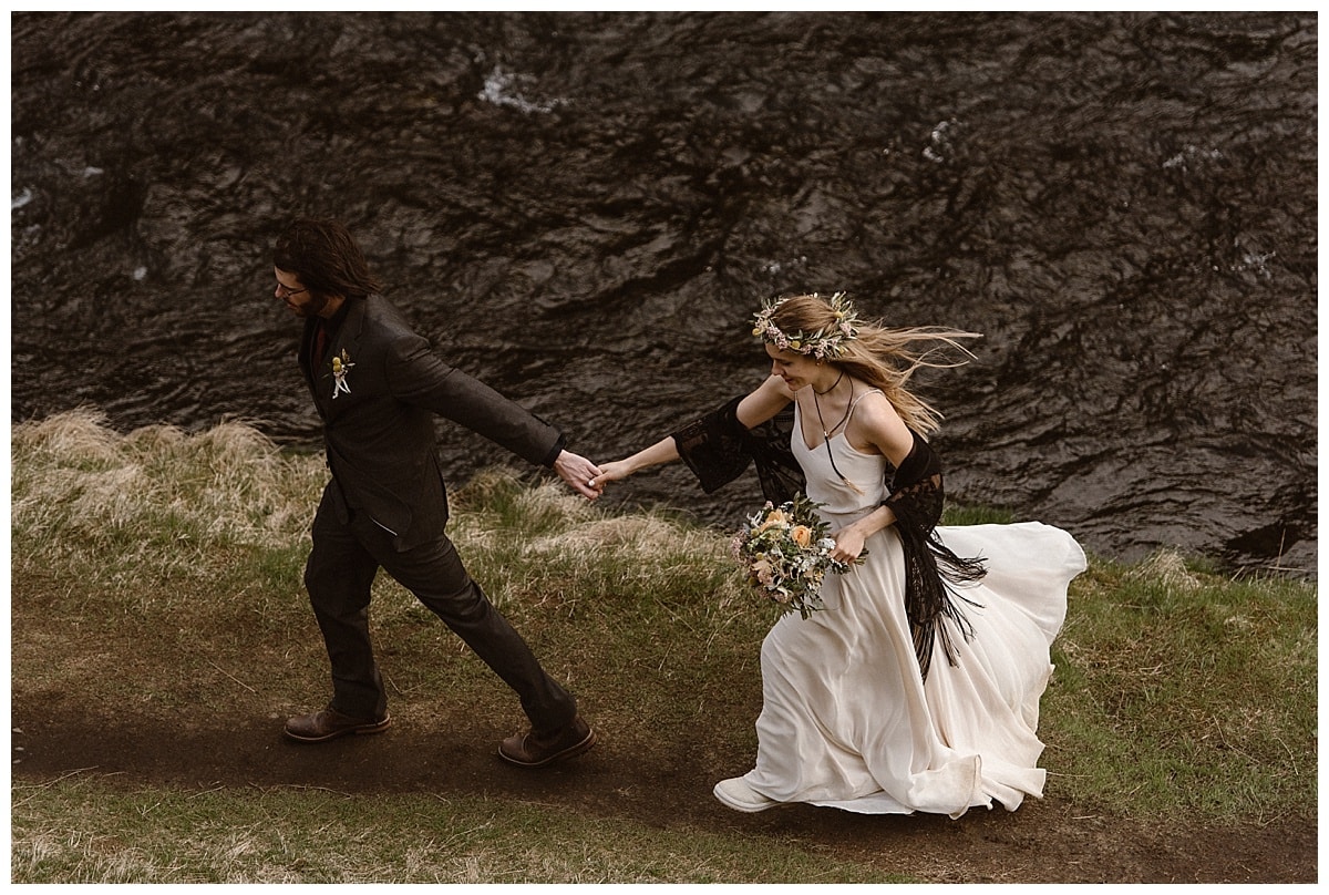 Bride and groom hiking while holding hands in Iceland. 