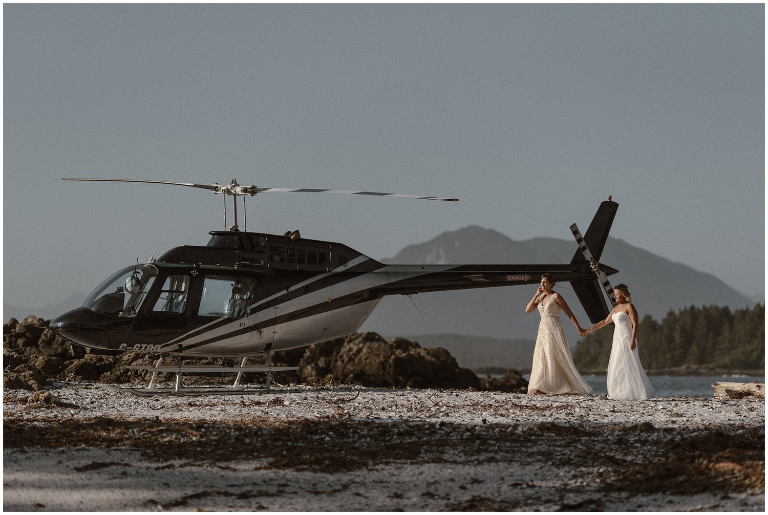 Two brides walk near a helicopter on their wedding day.