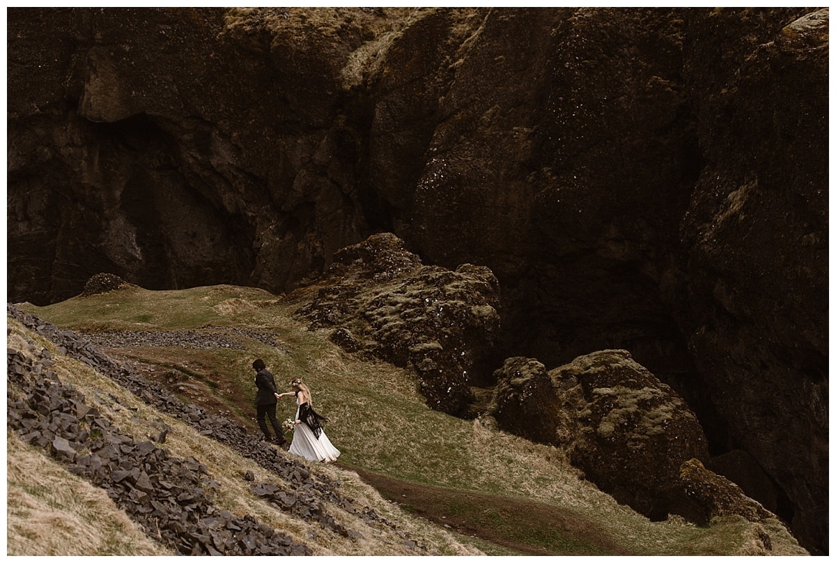 Bride and groom hiking while holding hands in Iceland. 