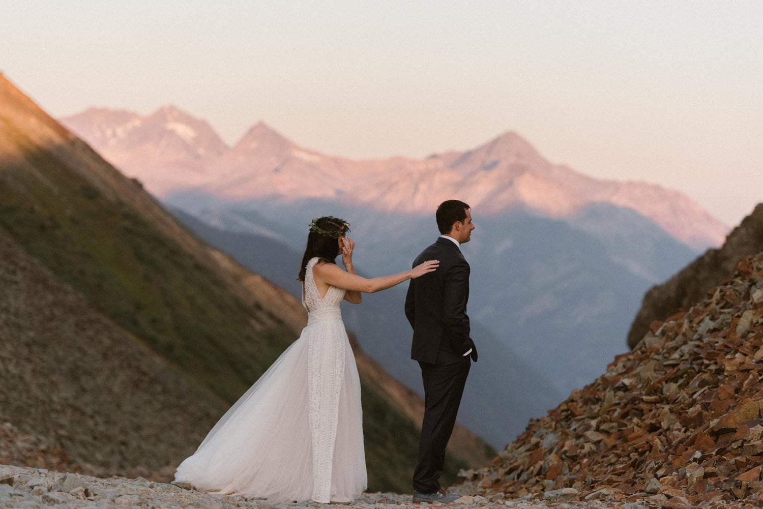 Bride approaches groom during sunrise for a first look on their elopement day. They are at Ophir Pass in Colorado. 