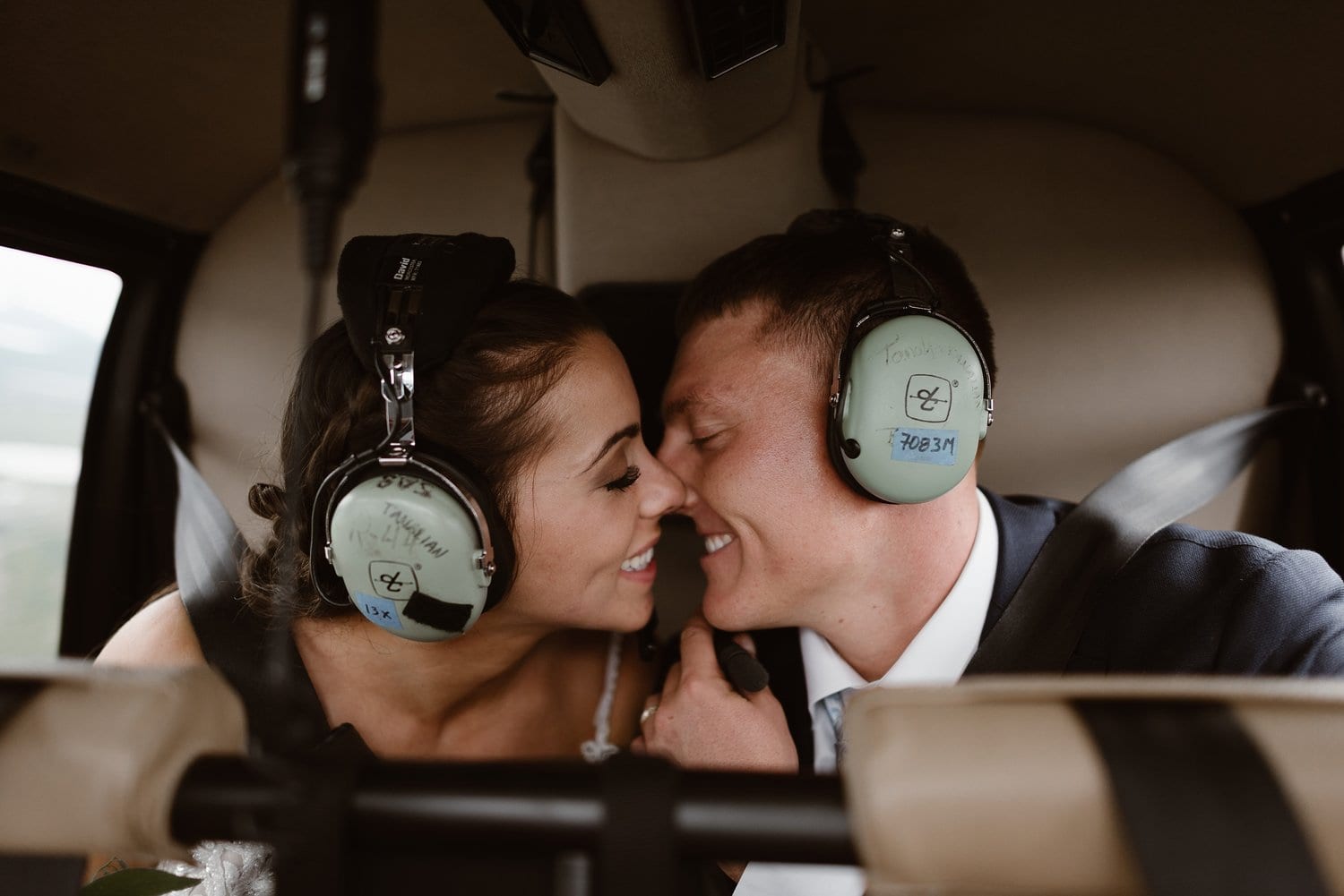 Bride and groom sitting in helicopter on elopement day in Alaska. 