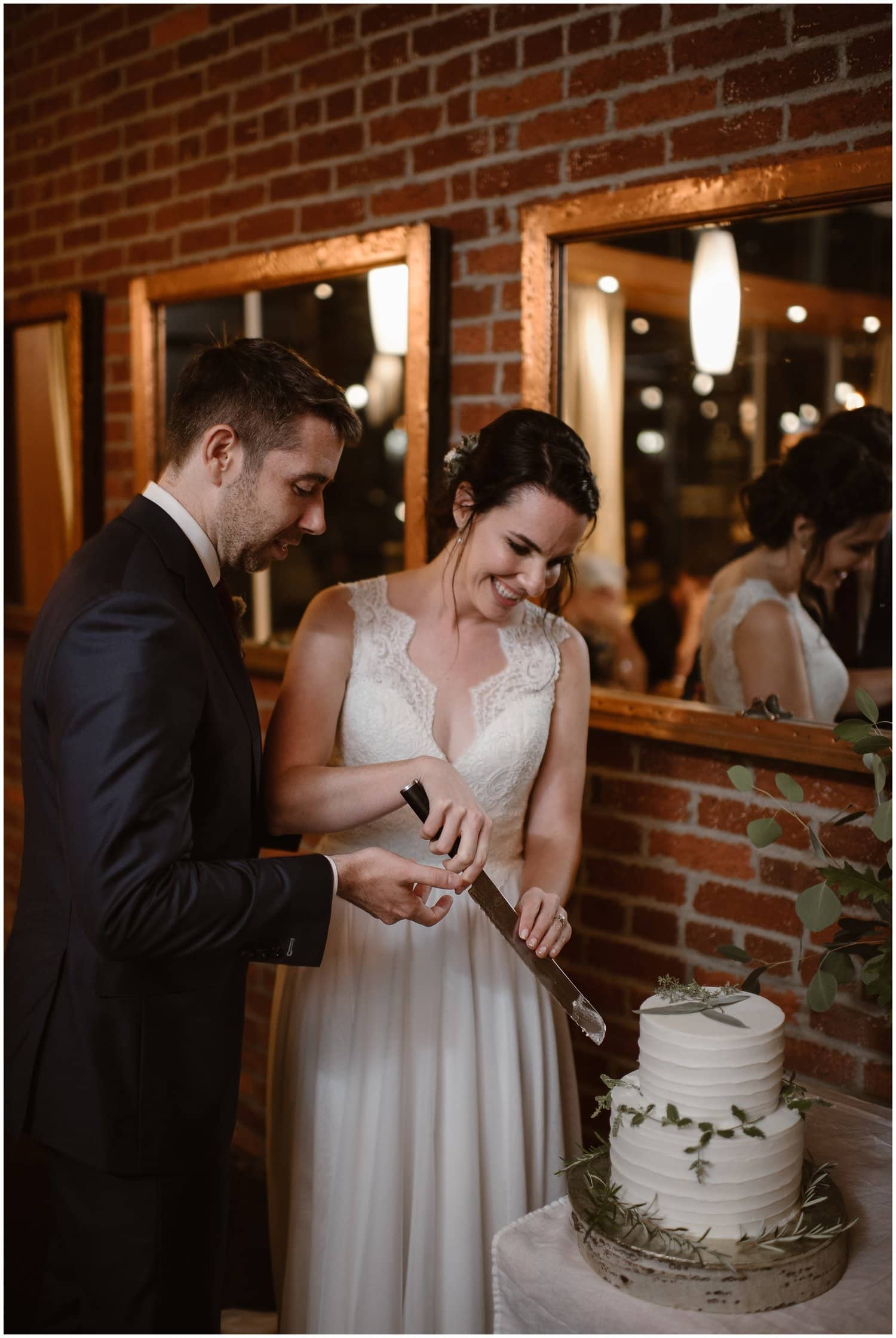 Bride and groom cut their wedding cake together during their reception. 