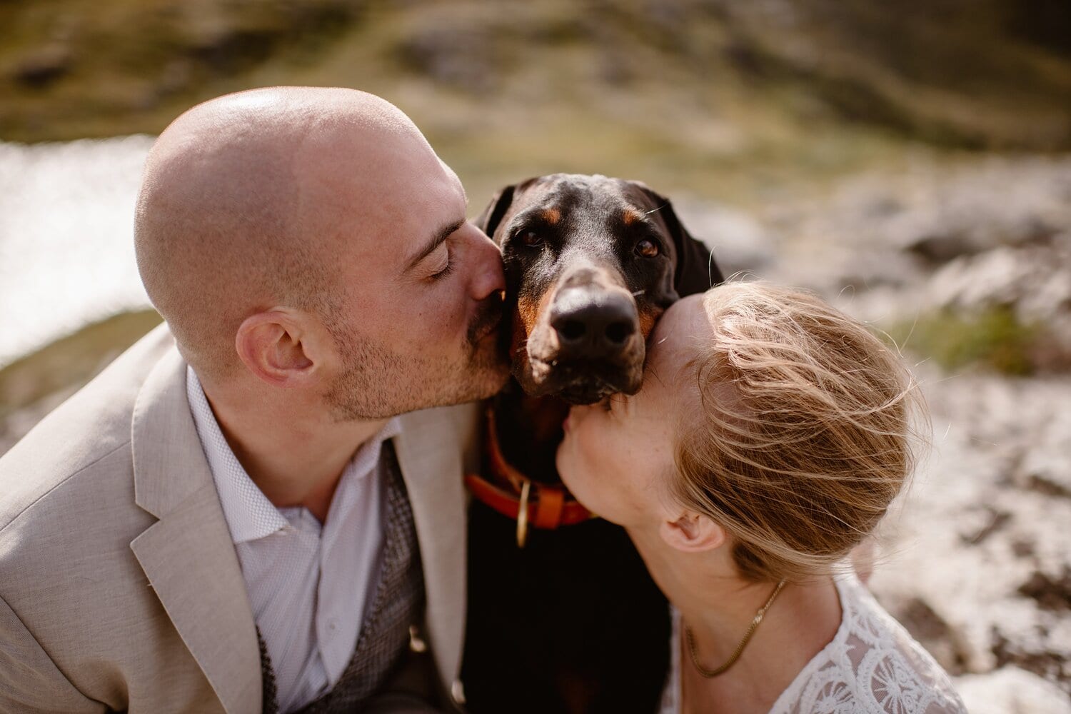 Bride and groom kiss their dog. They are at the Lofoten Islands in Norway.
