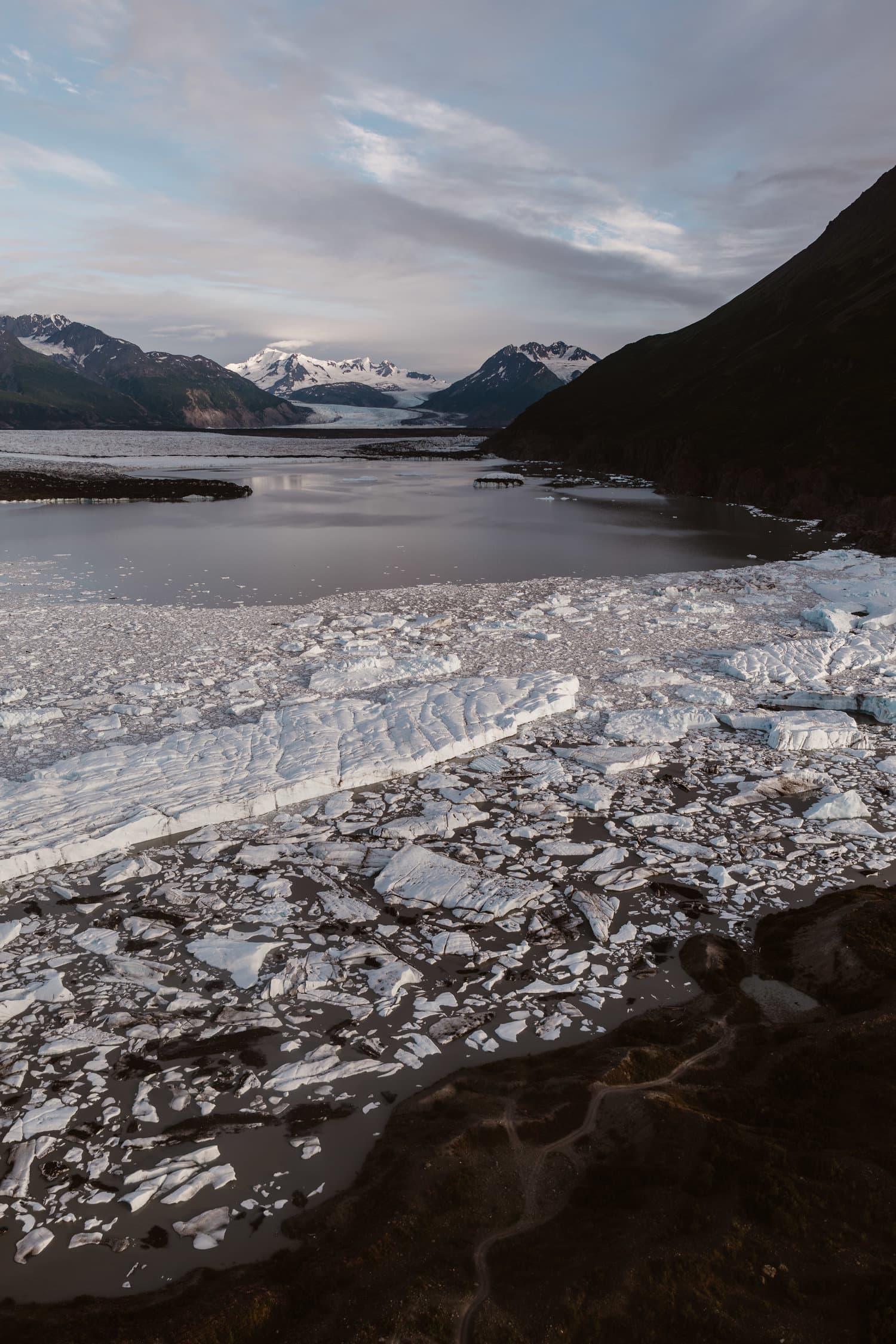 Landscape of Knik Glacier in Alaska. There are snow covered mountains in the background. 