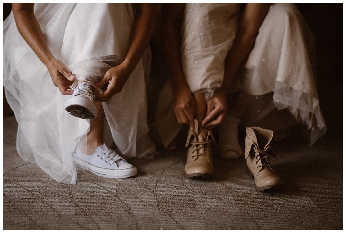 Close-up of two brides putting on their shoes on their elopement day. 