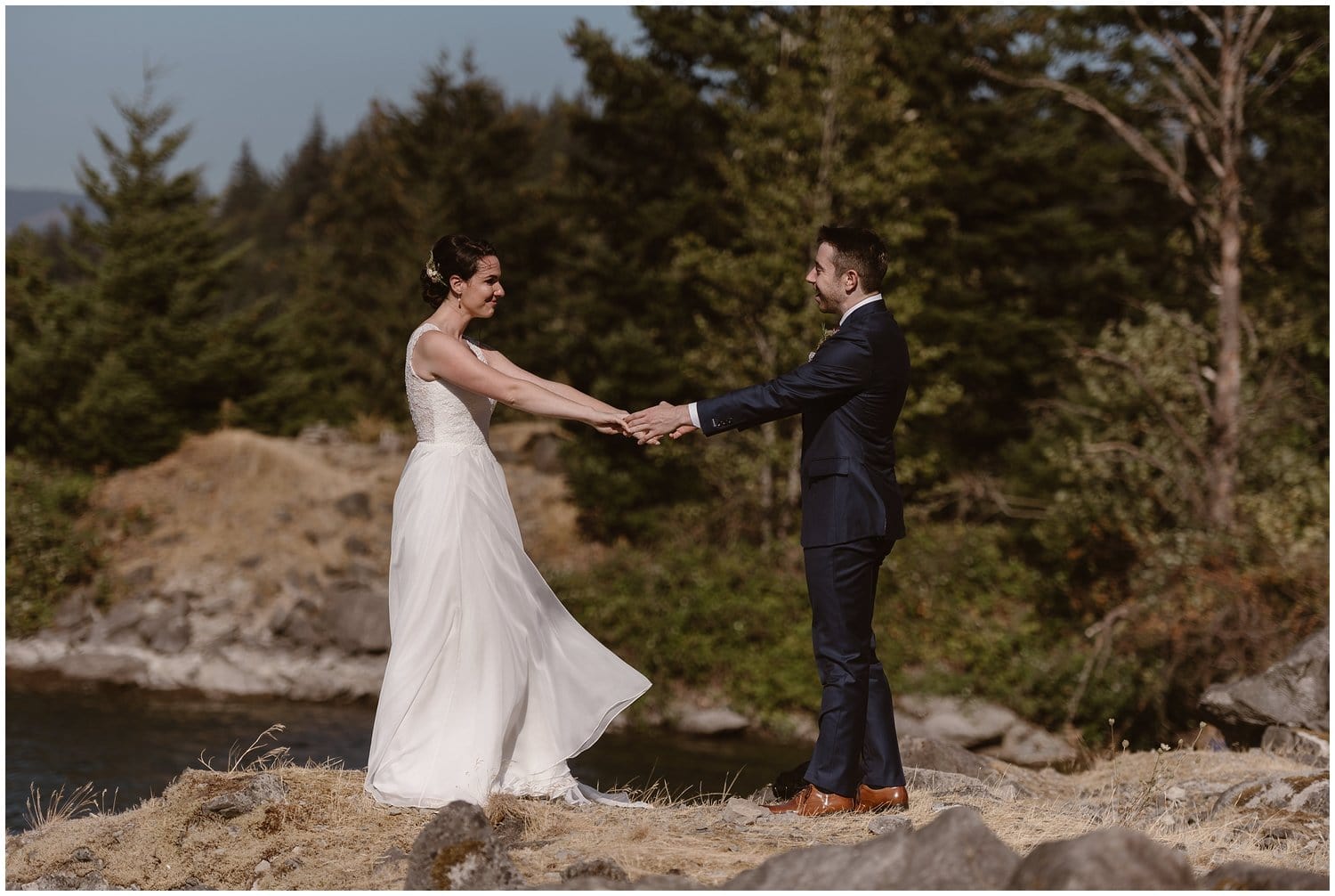 Bride and groom hold hands while sharing a first look on their elopement day at the Columbia River Gorge, in Oregon.