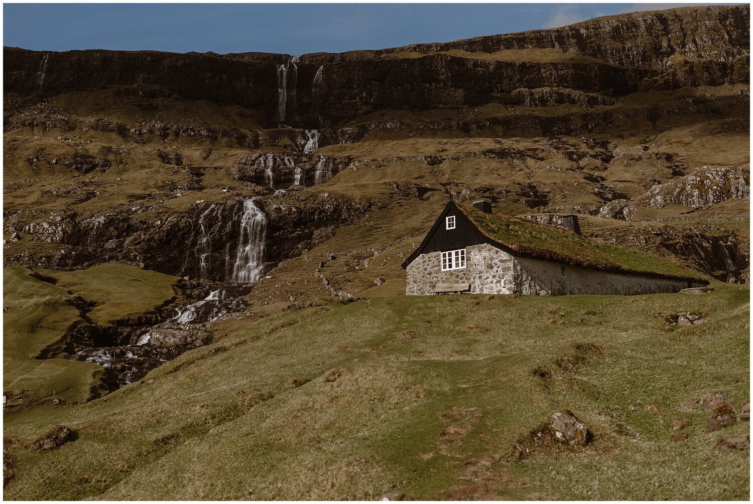 Landscape of waterfall and house at the Faroe Islands. 