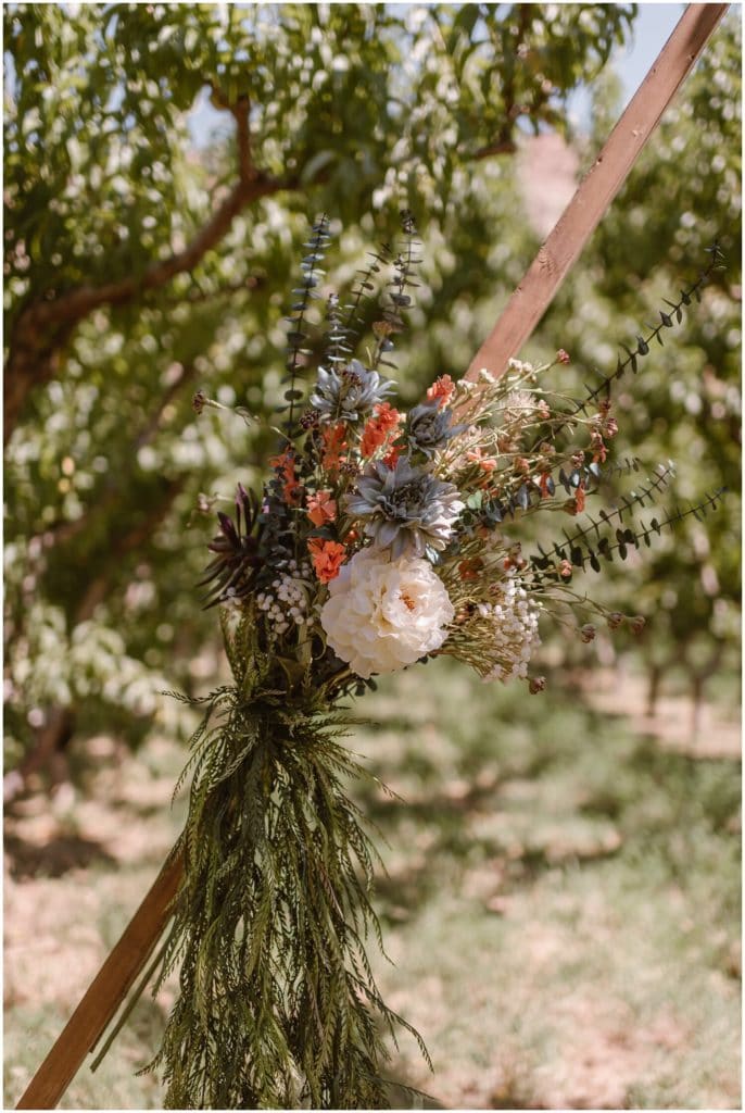 Close-up of floral arrangement, with peach orchard in background. 