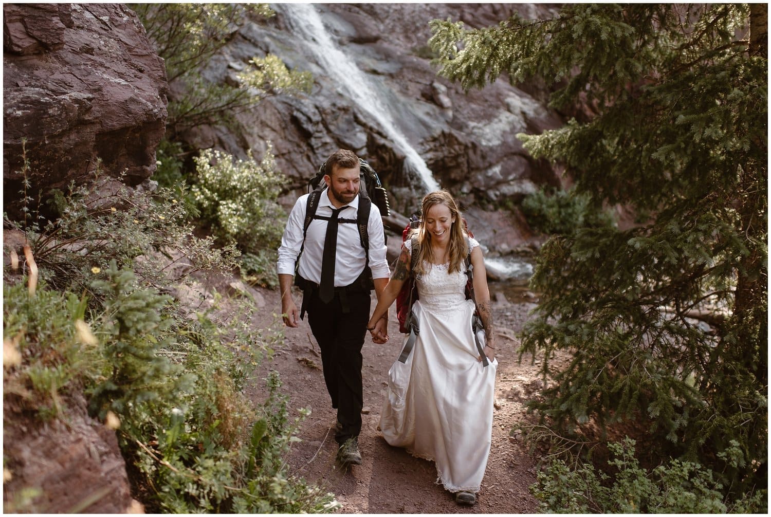 Bride and groom hike through forest in Ouray, Colorado. 