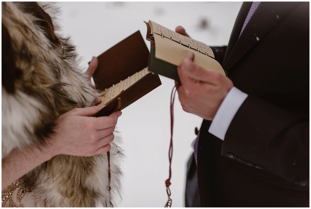 Close-up of bride and groom holding vow books.