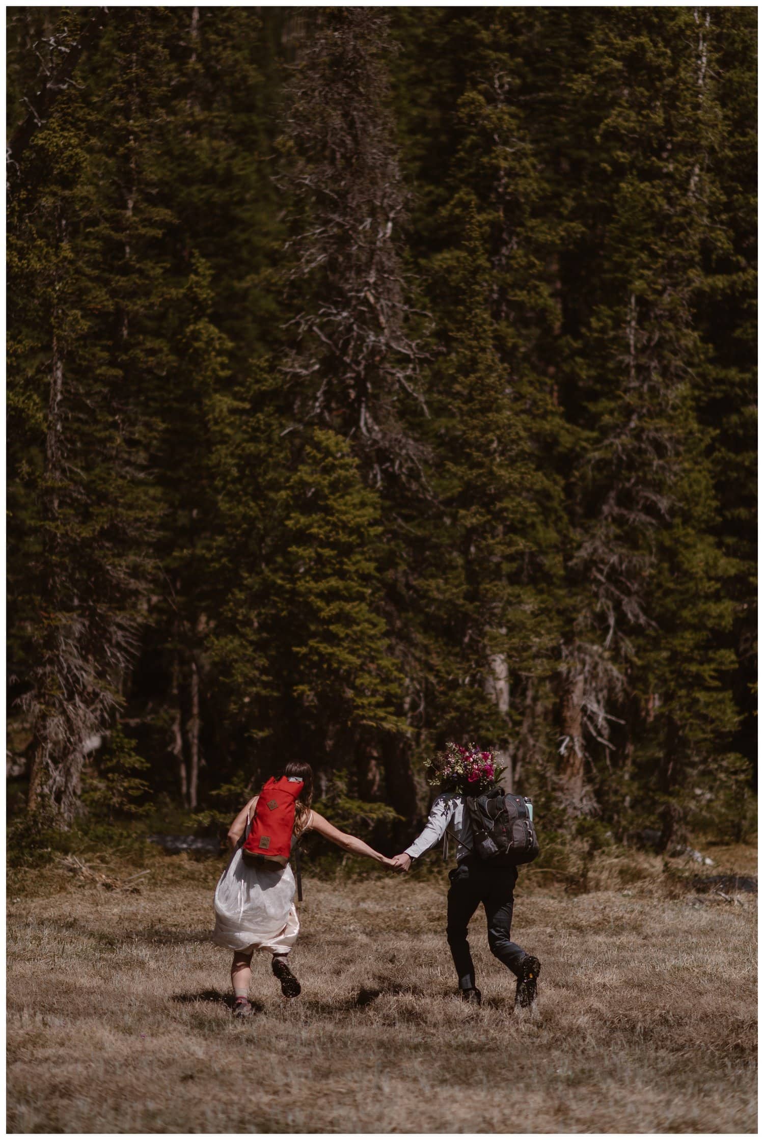 bride and groom holding hands and hiking on their elopement day in Colorado. 