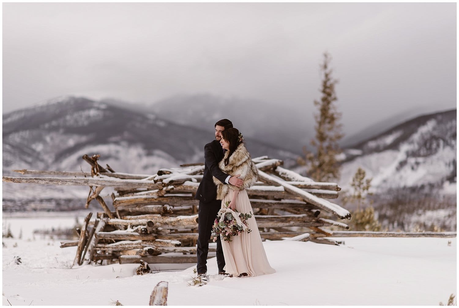 Bride and groom embrace in the snow at Sapphire Point, Colorado. 