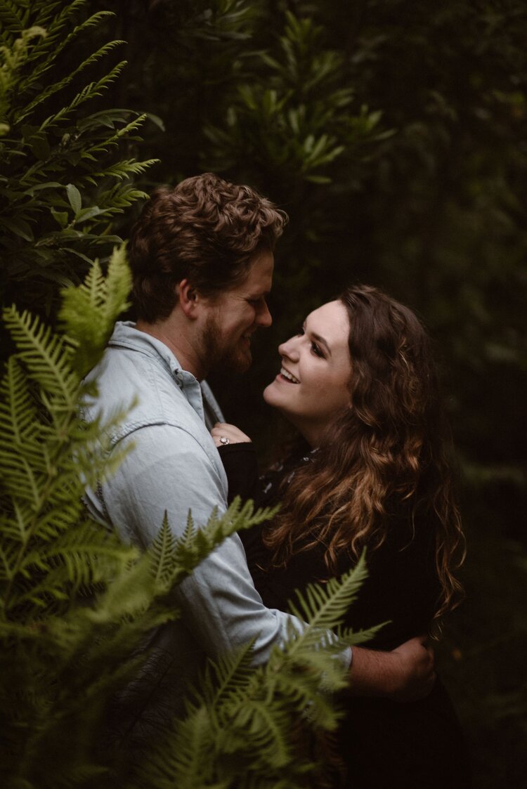 Bride and groom embrace in a forest in Monterey, California.