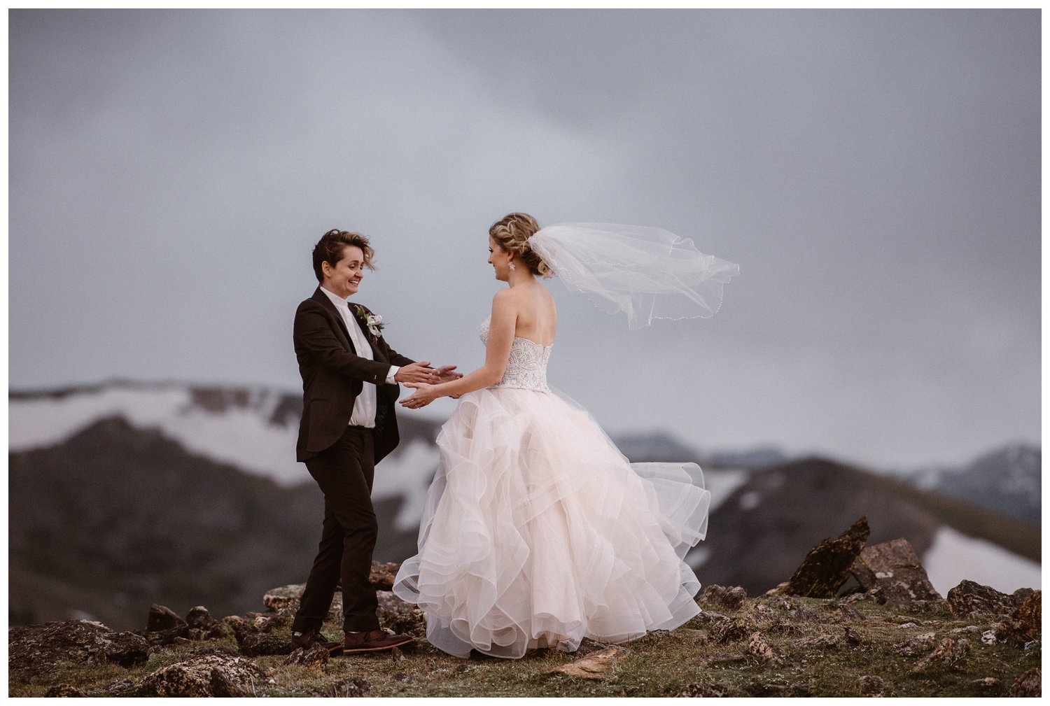 Two brides during their first look on top of a mountain. 