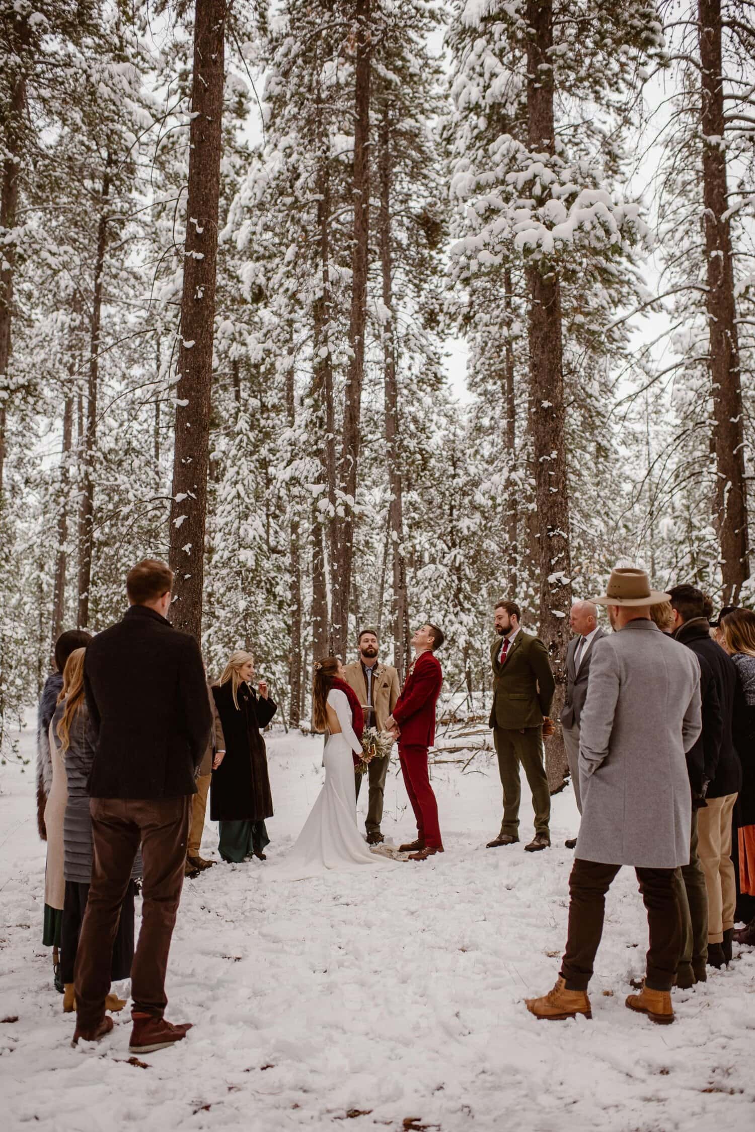 Bride and groom have an intimate wedding ceremony in the middle of a snow covered forest.