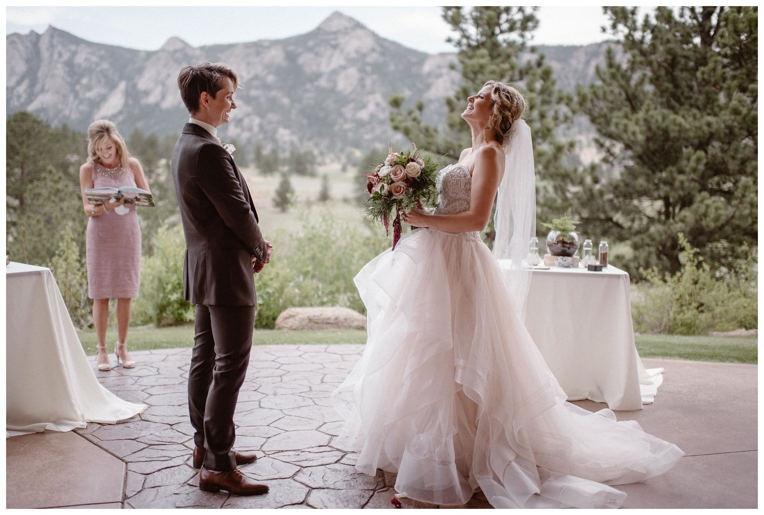 Two brides laugh during intimate elopement ceremony at the Stanley Hotel in Estes Park, Colorado. 