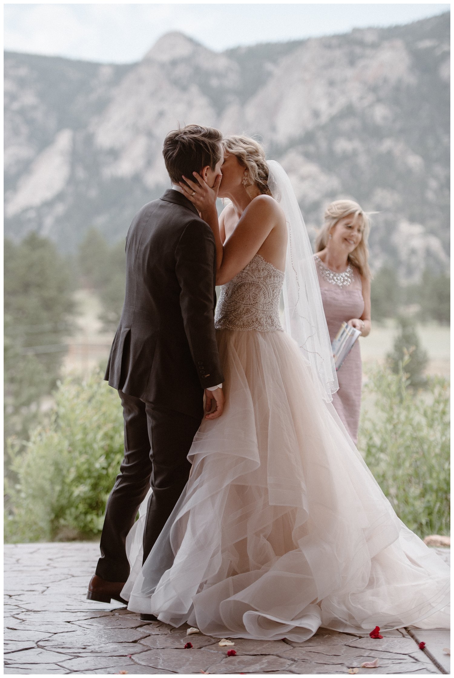 Two brides kiss during intimate elopement ceremony at Black Canyon Inn in Estes Park, Colorado. 